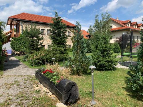 ein Haus mit einem Garten mit Blumen im Hof in der Unterkunft Villa Lypche in Bešeňová