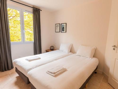 2 camas individuales en una habitación con ventana en Spacious and modern villa with large garden and BBQ area en Les Forges