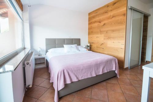 a bedroom with a large bed with a pink blanket at Hotel Penzion Kobala in Tolmin