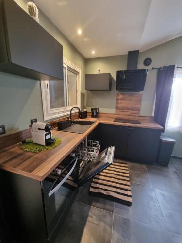 une cuisine avec un comptoir, un évier et un plan de travail dans l'établissement Ma Charmante Maison En Provence, à Lançon-Provence