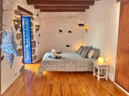 1 dormitorio con 1 cama con una cara en la pared en Charming Finca with beautiful private gardens, en Uga