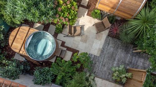una vista aérea de un jardín con un banco y sillas en Escale Rochelaise, gîte urbain avec SPA bain nordique et sauna tonneau en La Rochelle