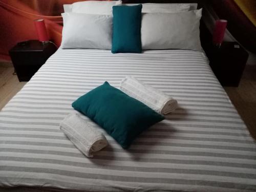 łóżko z niebiesko-białymi poduszkami w obiekcie petite maison chaleureuse w mieście Irvillac