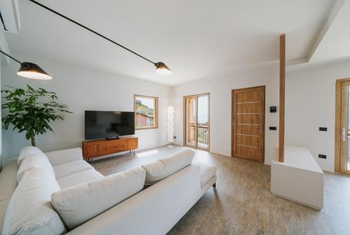 uma sala de estar com um sofá branco e uma televisão de ecrã plano em VIEW Garda Lake em Brenzone sul Garda