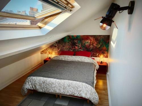 um quarto com uma cama com um quadro na parede em Duplex Cosy Place République em Lille