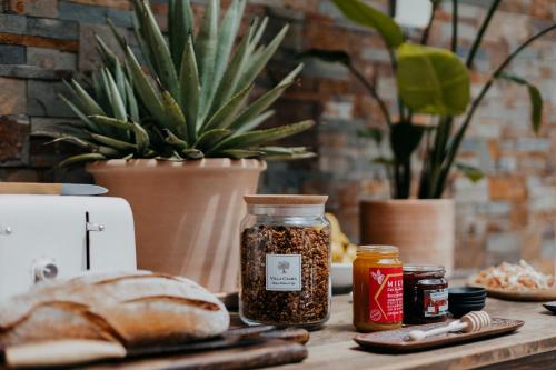 Una mesa con una hogaza de pan y dos frascos de especias. en Villa Calma - Maison d'hôtes & Spa, en Mottier