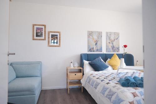a bedroom with a bed and a blue chair at Lakeside Traunsee Apartment in Altmünster
