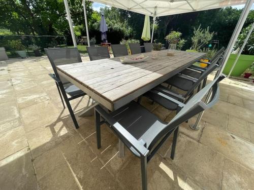 a wooden table with four chairs around it at Le Cognet : Maison 190 m2 Home 190 sqm 18' from Caen - 35 ' from Bayeux 