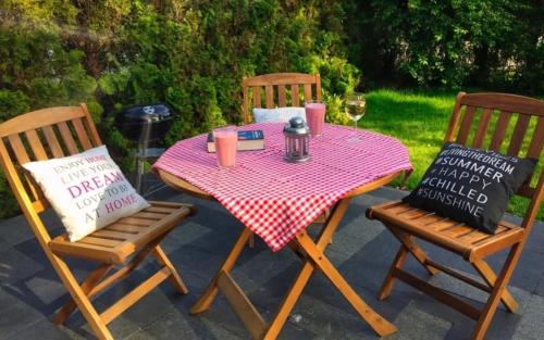 a table with two chairs and a table with a red checkered table cloth at Apartamenty Winniczki in Pobierowo