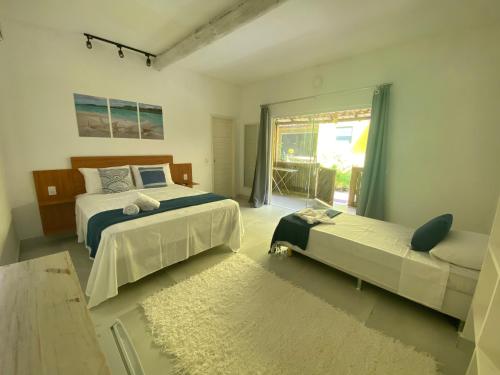 een slaapkamer met 2 bedden en een raam bij Villa Suites Gostoso - Condomínio Beira-mar in São Miguel do Gostoso