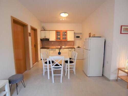 a kitchen with a table and chairs and a refrigerator at Tranquil Poolside Getaway in Mandre