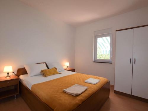 a bedroom with a bed with two towels on it at Tranquil Poolside Getaway in Mandre