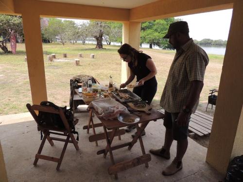 Un uomo e una donna in piedi intorno a un tavolo di Spot Jaguar Pantanal South Lodgen a Corumbá