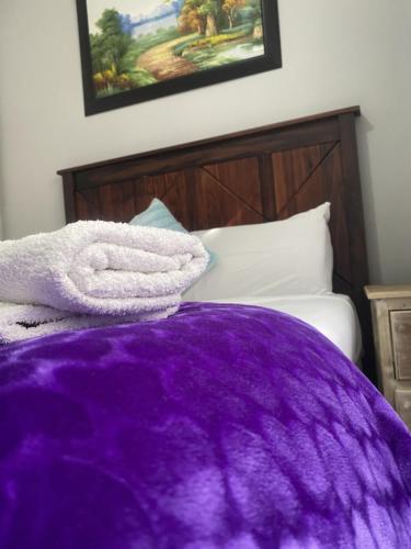 a purple blanket laying on top of a bed at Menlyn Mews Guesthouse in Pretoria