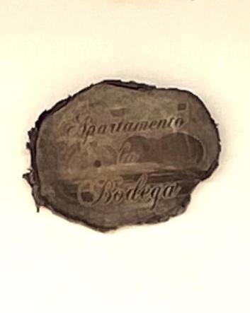 a coin is hanging on a white wall at Casa Del Amigo Carmelo in Ye