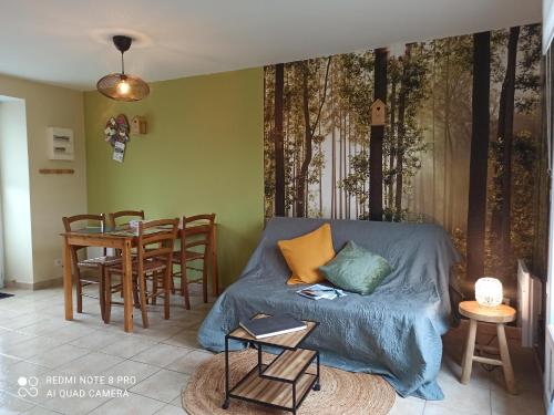 un salon avec un canapé et une table dans l'établissement La Campagne de Bas, à Heugueville-sur-Sienne