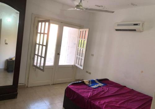 une chambre avec un lit dans une chambre avec une fenêtre dans l'établissement شاليه للايجار قريه تيباروز الساحل الشمالي, à Dawwār ‘Abd Allāh
