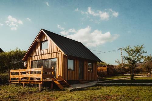 a small wooden cabin with a black roof at Beneháti kunyhók in Matrafured
