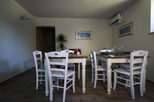 a dining room with a table and white chairs at matana b&b in Carmignano