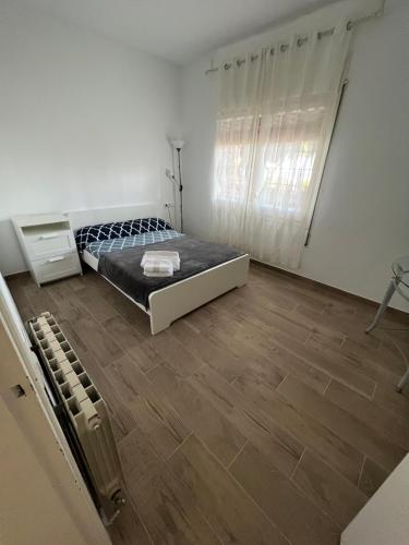 ein weißes Schlafzimmer mit einem Bett und Holzboden in der Unterkunft apartament close to beach in Cabrils