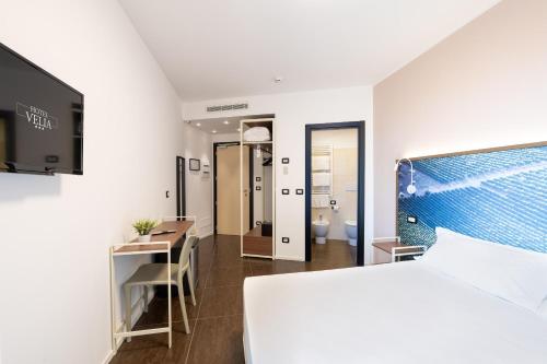 um quarto com uma cama, uma secretária e uma casa de banho em Hotel Velia em Grottammare
