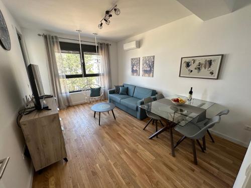 - un salon avec un canapé bleu et une table dans l'établissement Apartman JaVi, à Bar