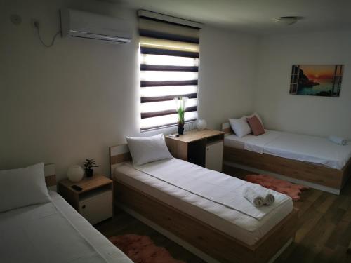 a small room with two beds and a window at Villa Boho Cherga in Belgrade