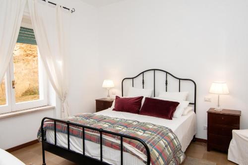 Un dormitorio con una cama con almohadas rojas y una ventana en CASA MARIA PIA en Sant'Agnello