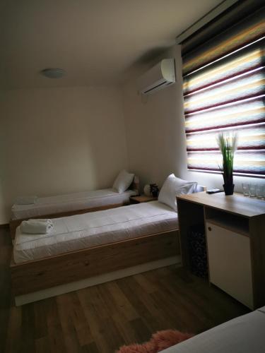 a bedroom with two beds and a window at Villa Boho Cherga in Belgrade