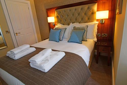 a hotel room with a bed with towels on it at The Townhouse Aberfeldy - Rooms & Breakfast in Aberfeldy
