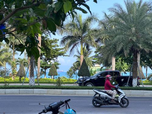 a person riding a motorcycle down the street at HAKU HOME Mini Apartments & Homestay in Quy Nhon