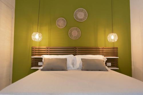1 dormitorio con 1 cama blanca grande y paredes verdes en Sunrise Sardinia Posada, en Posada