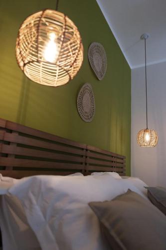 a bedroom with green walls with a bed and two lights at Sunrise Sardinia Posada in Posada