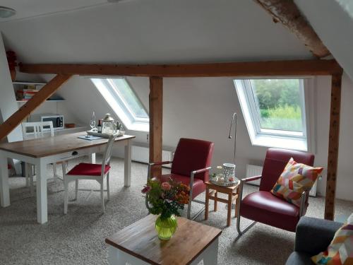 a living room with a table and chairs at Rêst en Romte in Burdaard