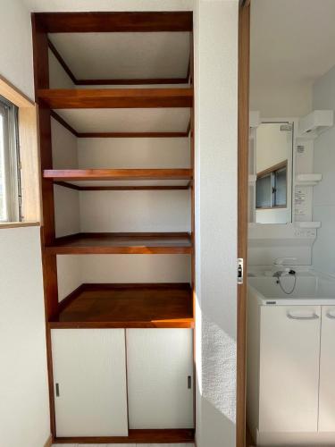 a closet with white cabinets and a refrigerator at 青梅森の宿 in Ome