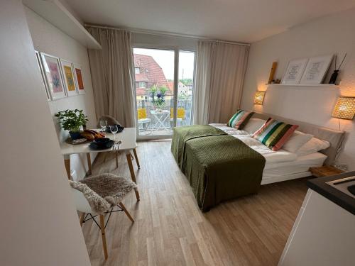 a bedroom with a bed and a desk and a window at Komfortables, barrierefreies Appartement mit sonnigem Balkon in der Nähe von Flughafen und Messe 30 in Leinfelden-Echterdingen