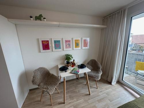 a table and two chairs in a room with a window at Komfortables, barrierefreies Appartement mit sonnigem Balkon in der Nähe von Flughafen und Messe 30 in Leinfelden-Echterdingen