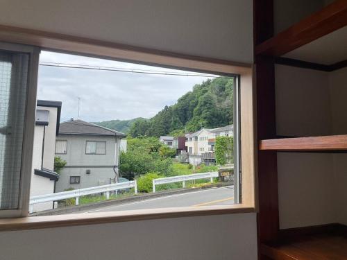 a window in a room with a view of a street at 青梅森の宿 in Ome