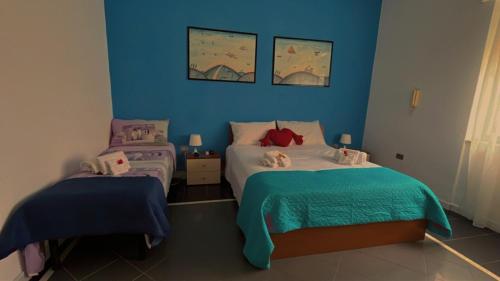 1 dormitorio con 2 camas individuales y paredes azules en Claudia House en Crotone