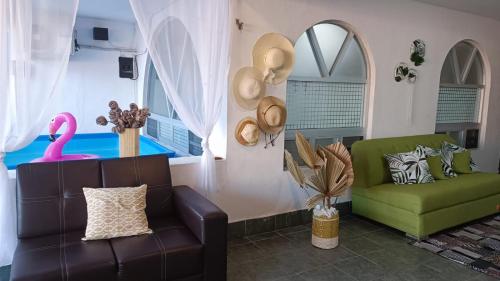 a living room with a couch and a pink chair at Casa Calis Cancún in Cancún