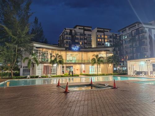 un bâtiment avec une piscine en face d'un bâtiment dans l'établissement EzyGo Homestay Kuching - P'Residence, à Kuching