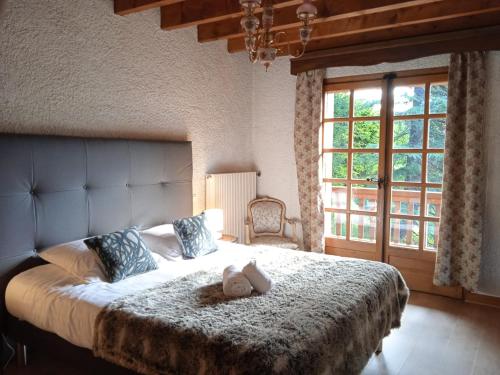 a bedroom with a large bed with a teddy bear on it at Chalet Horizon Blanc in Megève