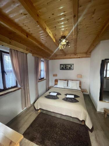 a bedroom with a bed and a wooden ceiling at Rustic Lodge Plitvice in Jezerce