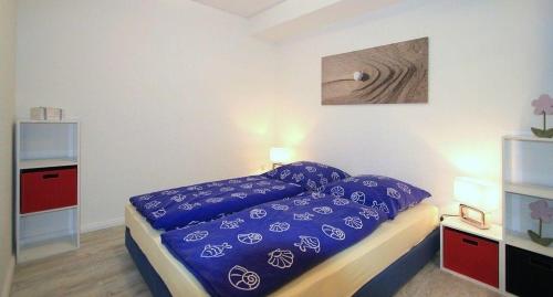 a bedroom with a bed with purple sheets on it at Gaestehaus-Achtern-Diek-Wohnung-4 in Süderhöft