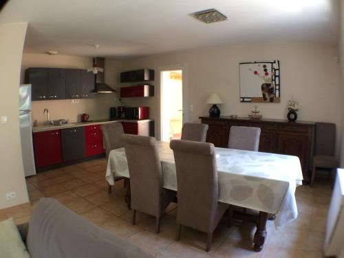 une cuisine et une salle à manger avec une table et des chaises dans l'établissement Gite Du Lavoir, à Saint-Geniès-de-Comolas