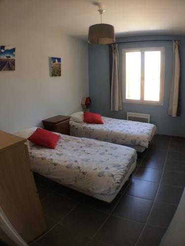 a room with two beds and a window at Gite Du Lavoir in Saint-Geniès-de-Comolas