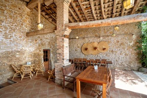 un patio al aire libre con mesa de madera y sillas en Can Muní, en Vilopríu