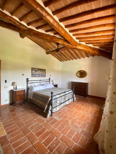 a bedroom with a bed and a wooden ceiling at Agriturismo La Peschiera in Casole dʼElsa