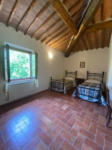 a room with two beds and a ceiling with a window at Agriturismo La Peschiera in Casole dʼElsa