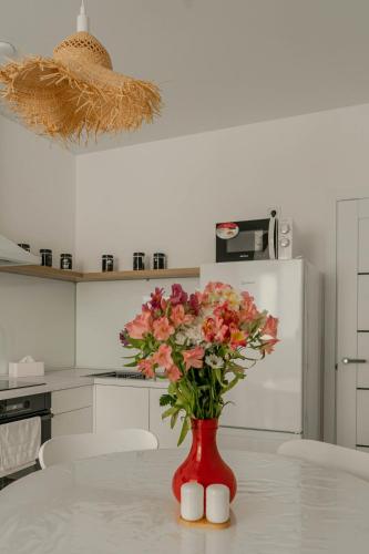 a red vase with flowers on a table in a kitchen at Apartment 5 star Werewolf in Strizhavka